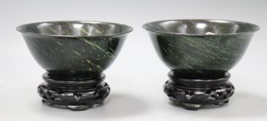A pair of modern Chinese dark jade bowls with hardwood stands, boxed
