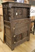 A 17th century style carved oak court cupboard having lunette-carved frieze, flower-heads and