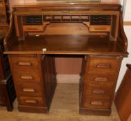 An oak twin pedestal desk enclosed by tambour W.122cm