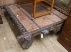 An Indonesian iron-bound hardwood elephant saddle coffee table on splayed supports, approx 138 x