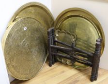 Seven Eastern brass trays and one stand