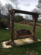A large Florentine style carved wood garden swing This lot may be viewed on site at a property at