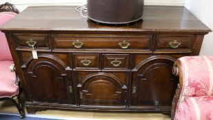 A George III style oak dresser base, fitted five drawers and three arcaded panelled cupboards, W.