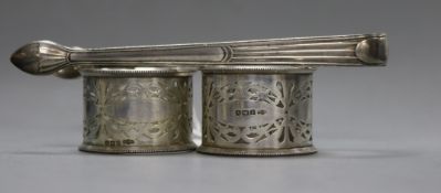 A pair of silver napkin rings and a pair of George III silver sugar tongs.