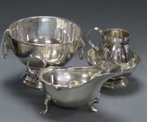 An Edwardian silver cream jug, a silver sauce boat, a silver sugar bowl and small silver rose