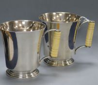 A pair of Art Deco silver mugs with turned ivory handles and flared rims, Adie Bros. Birmingham,
