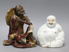 A Shiwan sang-de-boeuf glazed figure of a luohan and an enamelled porcelain figure of a Budai