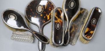 Seven silver and tortoiseshell mounted dressing table items.