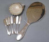 A silver hand mirror, a set of six silver butter knives, a silver butter shell and knife.