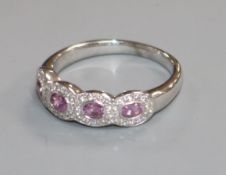 An 18ct white gold, pink sapphire and diamond quadruple cluster ring, size R.