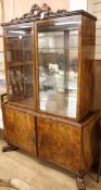 A 1930's walnut china display cabinet on cupboard base W.140cm