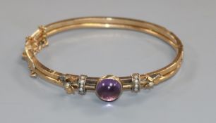 An early 20th century yellow metal, cabochon amethyst and seed pearl set hinged bracelet.