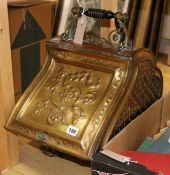 A Victorian embossed brass coal scuttle and implements