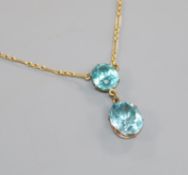 A yellow metal and oval facet cut blue zircon drop pendant necklace, on 9ct gold chain, pendant