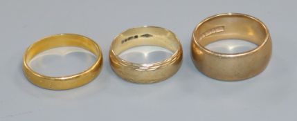 A 22ct gold wedding band and two 9ct gold wedding bands