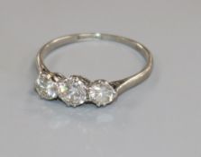 A platinum and three stone diamond ring, size Q.