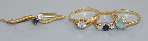 Three assorted 18ct gold and gem set dress rings and a yellow metal sapphire and diamond set bar