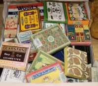 A collection of old cigarette packets and tobacco tins, some cigarettes included