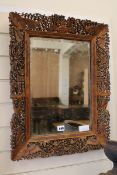 A Chinese carved wood mirror W.48cm