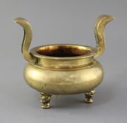 A Chinese bronze ding censer, 19th century, with flying scroll handles, three mask feet, h. 17.