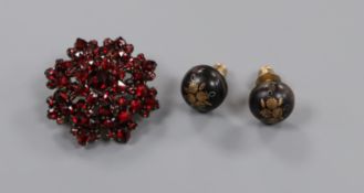 A pair of Edwardian tortoiseshell pique ear studs and a yellow metal and garnet set brooch.