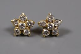 A pair of yellow metal and diamond set flower head earstuds, (one back missing).