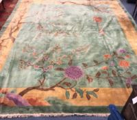 A Chinese carpet, the centre woven with flowering prunus and other shrubs on a celadon ground,