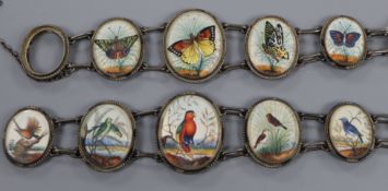 Two early 20th century white metal bracelets, one inset with five graduated Indian? painted ivory