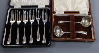 A cased set of six 1940's silver pastry forks and a cased pair of silver cream ladles.