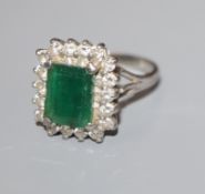 An 18ct white gold, emerald and diamond rectangular cluster ring, size N.