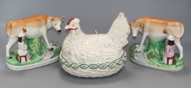 A pair of Staffordshire pottery cow and milk maid groups and a hen dish and cover Staffordshire