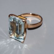 A yellow metal and large emerald cut blue topaz dress ring, size N.