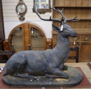 A large bronzed metal model of a recumbent stag H.88cm, W.100cm