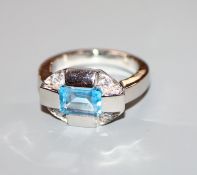 A stylish 750 white metal, blue topaz and diamond five stone dress ring, size N.