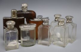 A silver-mounted hip flask, two other hip flasks and a quantity of toilet bottles