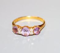 An 18ct, three stone amethyst and four stone diamond dress ring, size L.