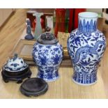 A large blue and white Chinese and a smaller similar vase with wooden cover, two stands and a cover