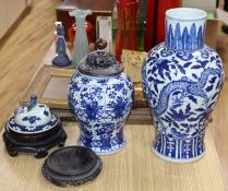 A large blue and white Chinese and a smaller similar vase with wooden cover, two stands and a cover