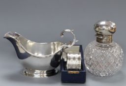 A George V silver sauceboat, a late Victorian silver mounted glass scent bottle and a cased silver