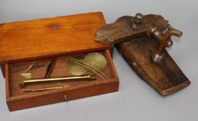 A decorated wall tap and a cased set of brass scales