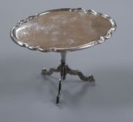 A Dutch 19th century miniature white metal tilt-top table, the oval top with piecrust edge, height