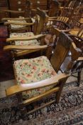 A set of four 1930's carved oak elbow chairs, marked Jas Schoolbred & Co