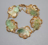 A 14k yellow metal and jade bracelet, each link mounted with jade carved as goldfish.