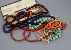 Assorted necklaces including coral and amethyst, a carved coral pendant and a pair of folding