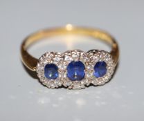 A modern 18ct gold, sapphire and diamond set triple cluster ring, size Z.