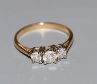 A modern 18ct gold and three stone diamond ring, with IGI report stating the total diamond weight to