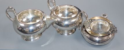A modern silver cream jug and sugar bowl, a silver coaster, silver taste vin and silver tea strainer