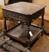 A carved oak two tier table W.61cm