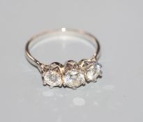 An 18kt white metal and three stone diamond ring, total diamond weight approximately 1.00ct, size