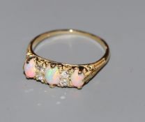 An 18ct, three stone white opal and four stone diamond half hoop ring, size P.